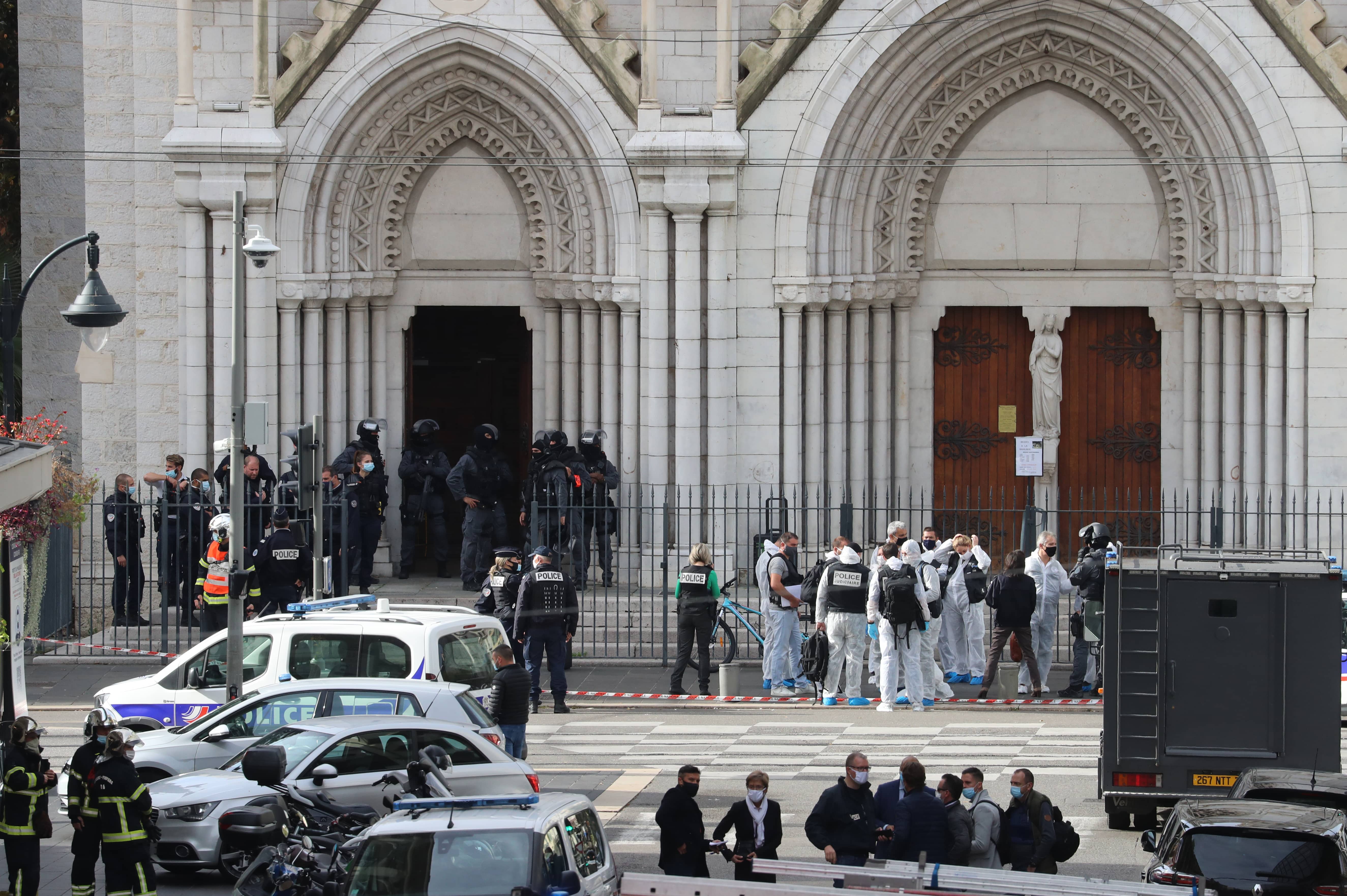 French members of the elite tactical police unit RAID enter to search the Basilica of Notre-Dame de Nice as forensics officers wait after a knife attack in Nice on October 29, 2020. (AFP)