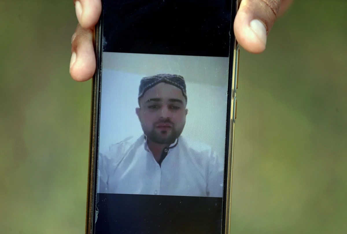 A villager displays a picture of Ali Hassan, a suspect in an attack on two people with a meat cleaver in Paris last month, in his native village of Kotli Qazi, Pakistan, Saturday, Oct. 3, 2020. Hassan is in jail in Paris, but just three years ago he started out like other young men who leave Pakistan for Europe with dreams of a better life. (AP)