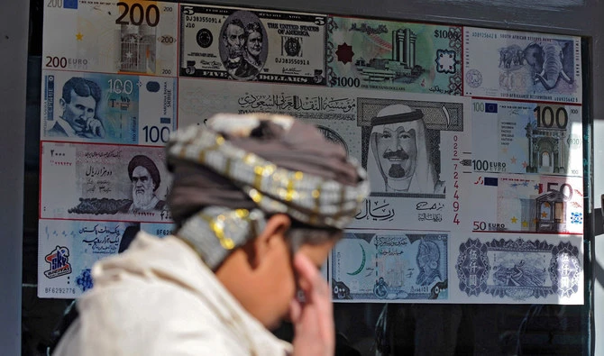A pedestrian walks past a foreign currency exchange shop in Quetta on Dec. 8, 2011. (AFP/File)