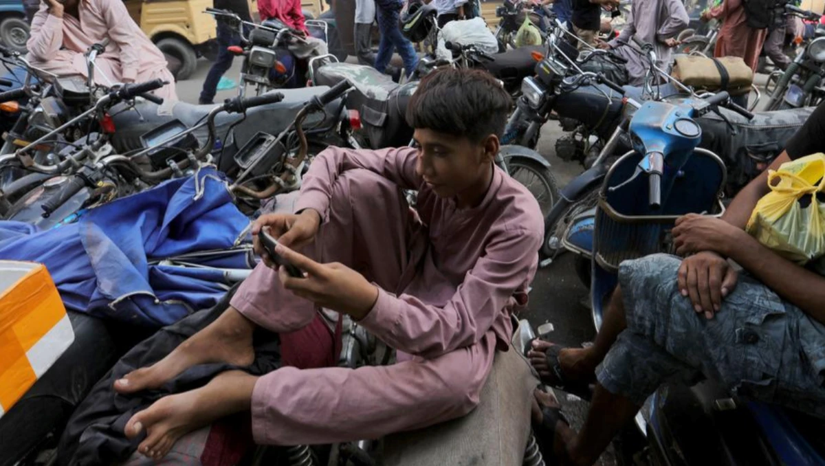 A youngster uses the social media app TikTok on his phone, at a market in Karachi, Pakistan, Tuesday, July 21, 2020. (AP)