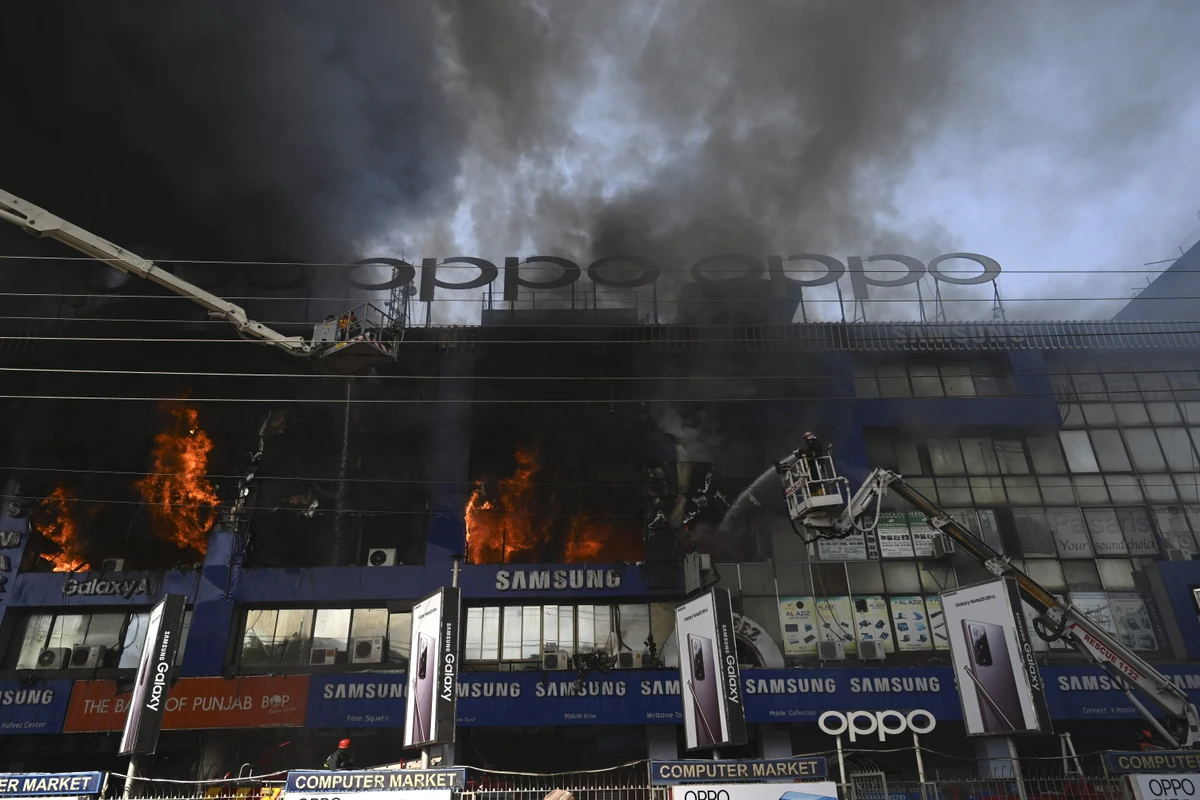 Firefighters try to extinguish a fire that broke out in a four-storey commercial building that houses mobile, laptop and electronics plaza in Lahore on October 18, 2020. (AFP)