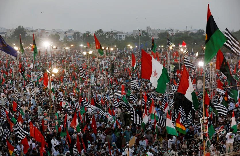 Supporters of Pakistan Democratic Movement (PDM), an alliance of political opposition parties, wave flags as they listen to their leaders during an anti-government protest rally in Karachi, Pakistan October 18, 2020. (REUTERS)