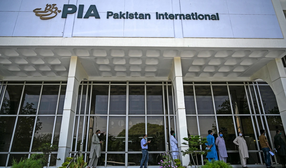 People stand in queue as they wait their turn to buy flight tickets outside Pakistan International Airlines (PIA) office in Islamabad on July 1, 2020. (AFP/File)