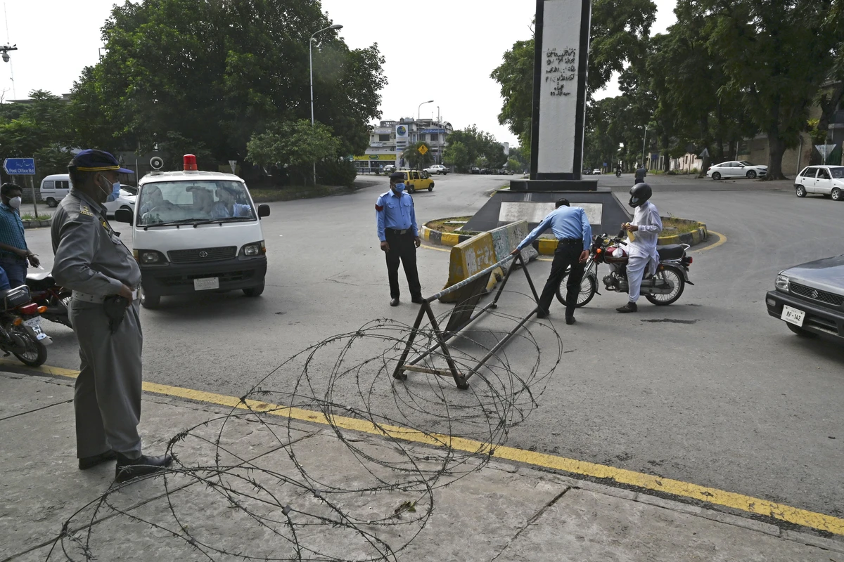 Police officers wearing facemasks stand beside motorists next to a street sealed by the authorities at a residential area in Islamabad on June 25, 2020 as COVID-19 coronavirus cases continue to rise. (AFP)