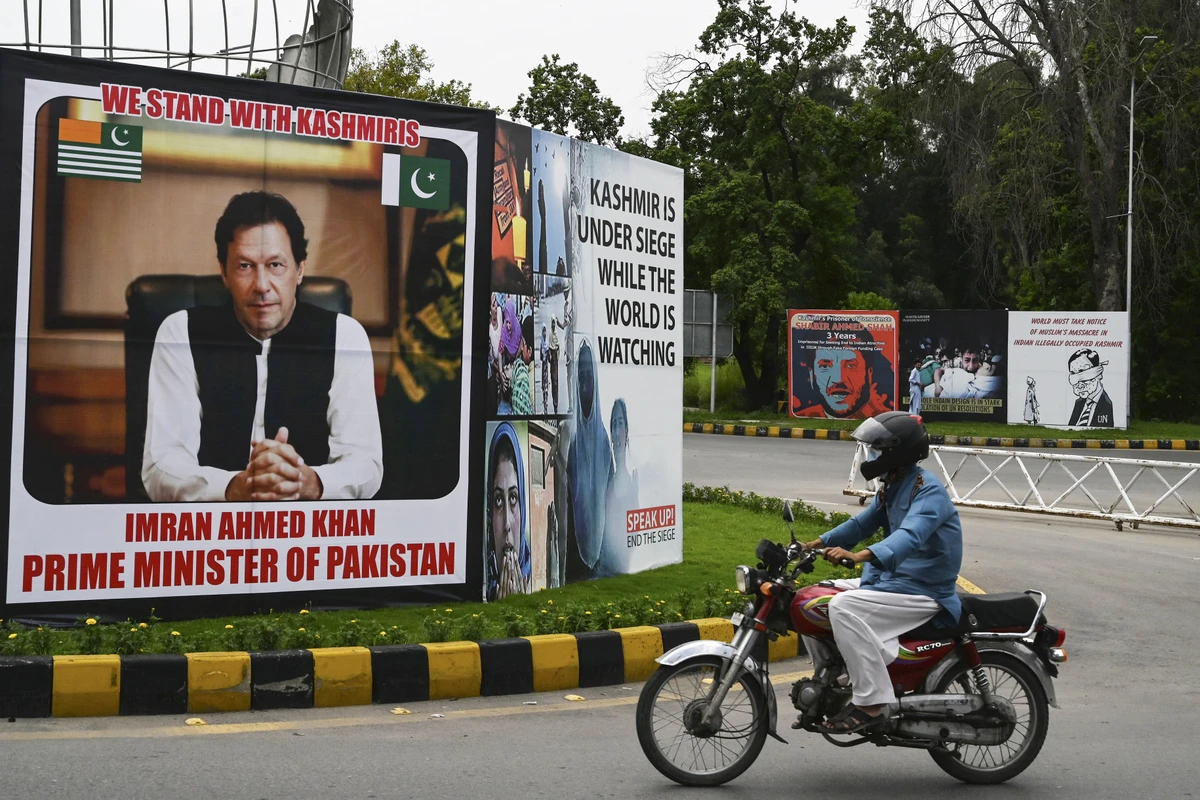 A motorcyclist rides past a billboard displaying a picture of Pakistan's Prime Minister Imran Khan along a street in Islamabad on August 4, 2020 ahead of the Yaum-i-Istehsal or Day of Exploitation on August 5, on the first anniversary after India scrapped Muslim-majority region Kashmir's semi-autonomous status and imposed a major security clampdown. (AFP)