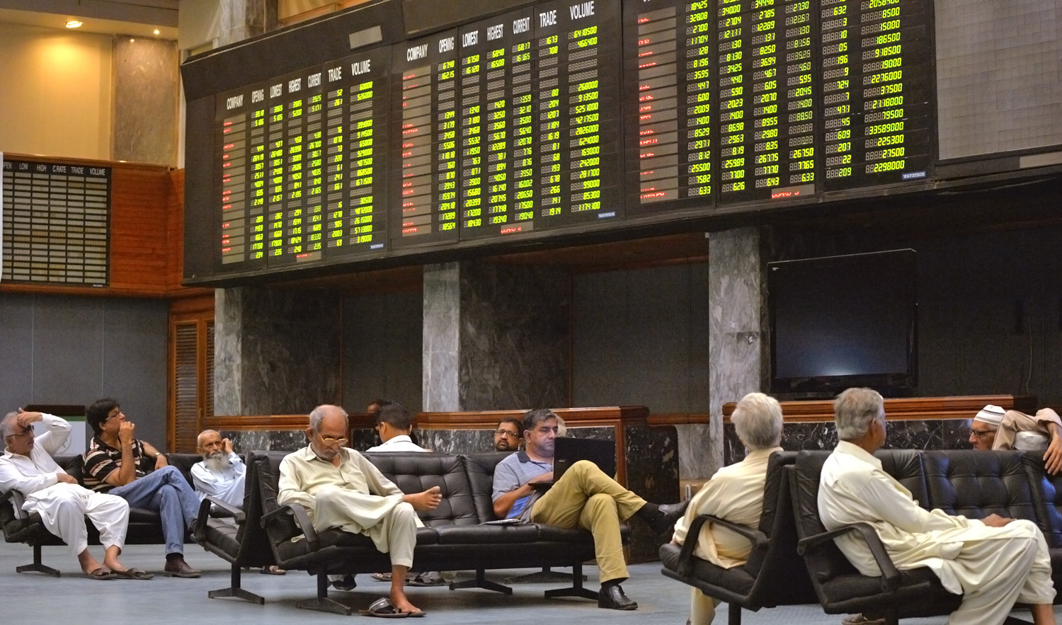 In this file photo, Pakistani stockbrokers watch the share prices board during a trading session at the Pakistan Stock Exchange (PSE) in Karachi on June 15, 2016. (RIZWAN TABASSUM/AFP)