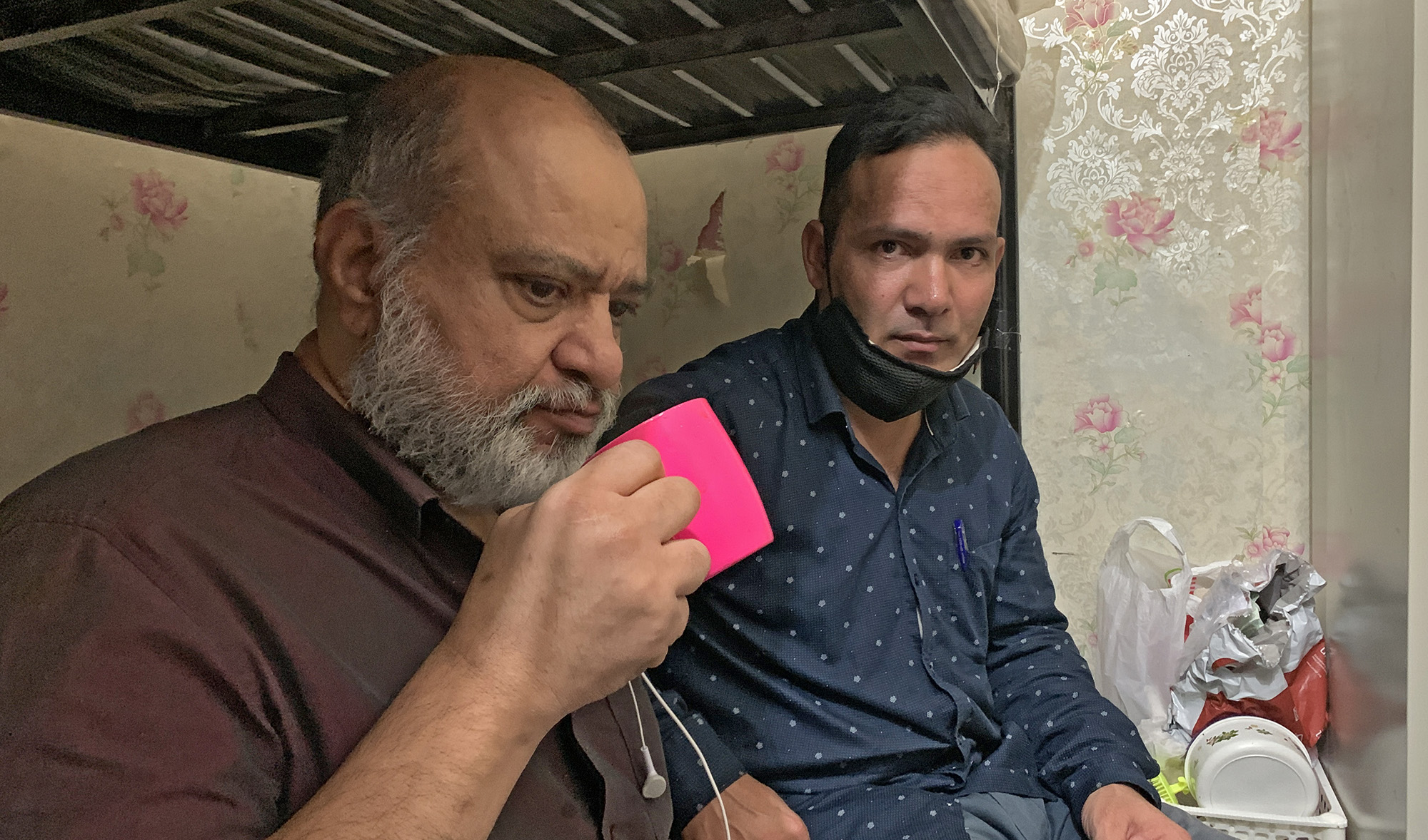 Tomichan Puthuparambil Thomas, left, and Mohammed Asad talk to Arab News at their apartment in Karama, Dubai on Nov. 7, 2020. (AN photo by Asma Ali Zain)
