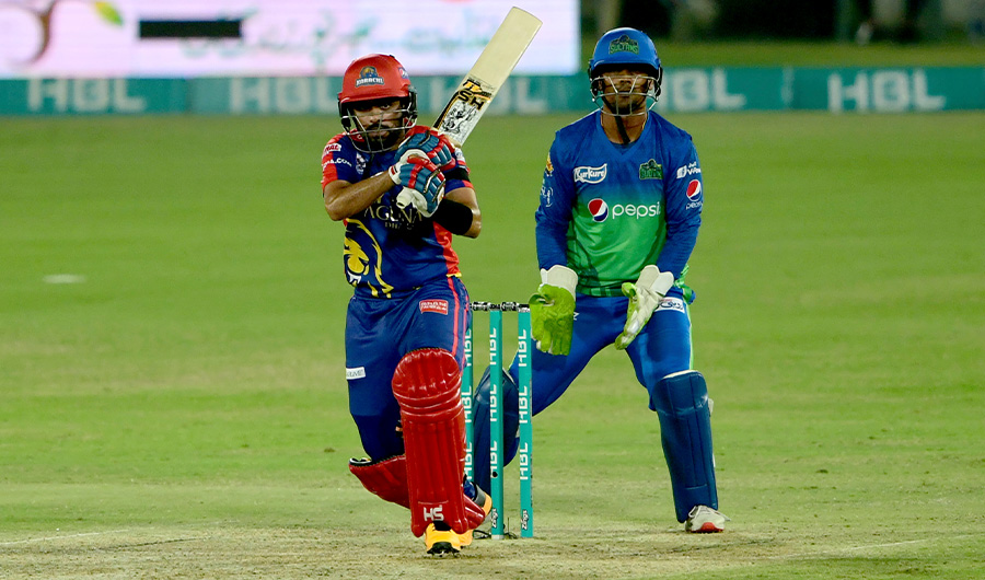 Karachi Kings batsman Babar Azam, front, follows the ball after playing shot while Multan Sultans wicketkeeper Zeeshan Ashraf watches during the Pakistan Super League T20 first qualifier cricket match at National Stadium in Karachi, Pakistan, Saturday, Nov. 14, 2020. (AP)