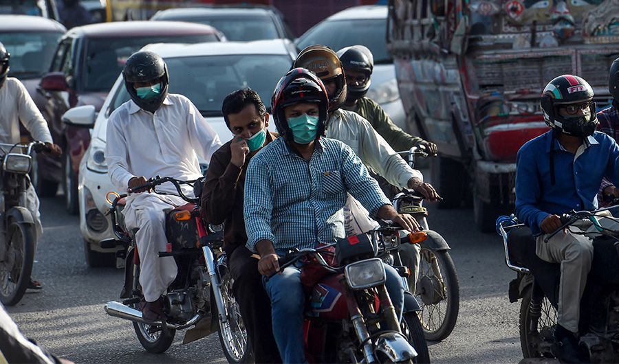 Motorists wearing facemasks as a preventive measure against the spread of the COVID-19 coronavirus make their way on a busy street in the Pakistan's port city of Karachi on July 15, 2020. (AFP)