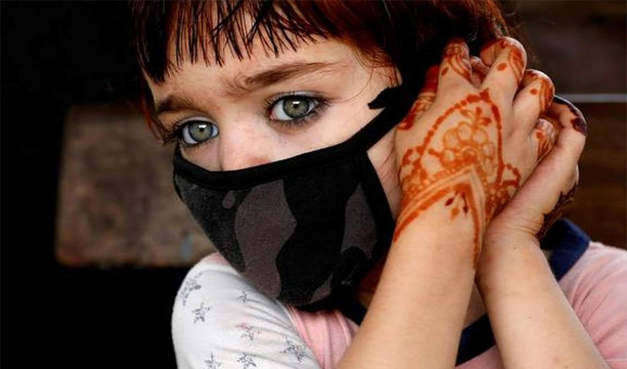 A girl adjusts her protective face mask as the outbreak of the coronavirus disease (COVID-19) continues in Karachi on June 9, 2020. (REUTERS/File)