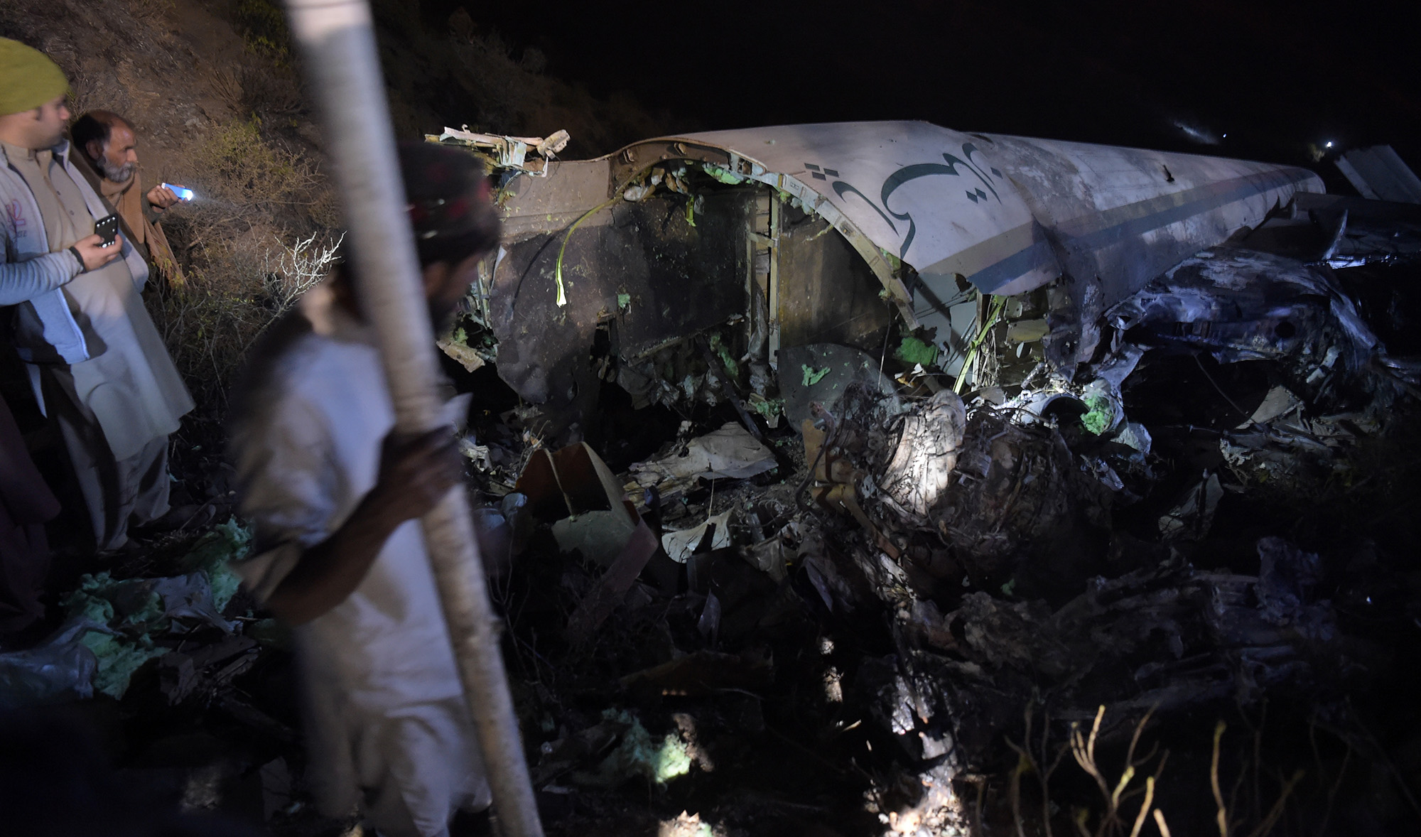 Pakistanis residents search for victimes around the wreckage of the crashed PIA passenger plane Flight PK661 at the site in the village of Saddha Batolni in the Abbottabad district of Khyber Pakhtunkhwa province on Dec. 7, 2016. (AFP/File)