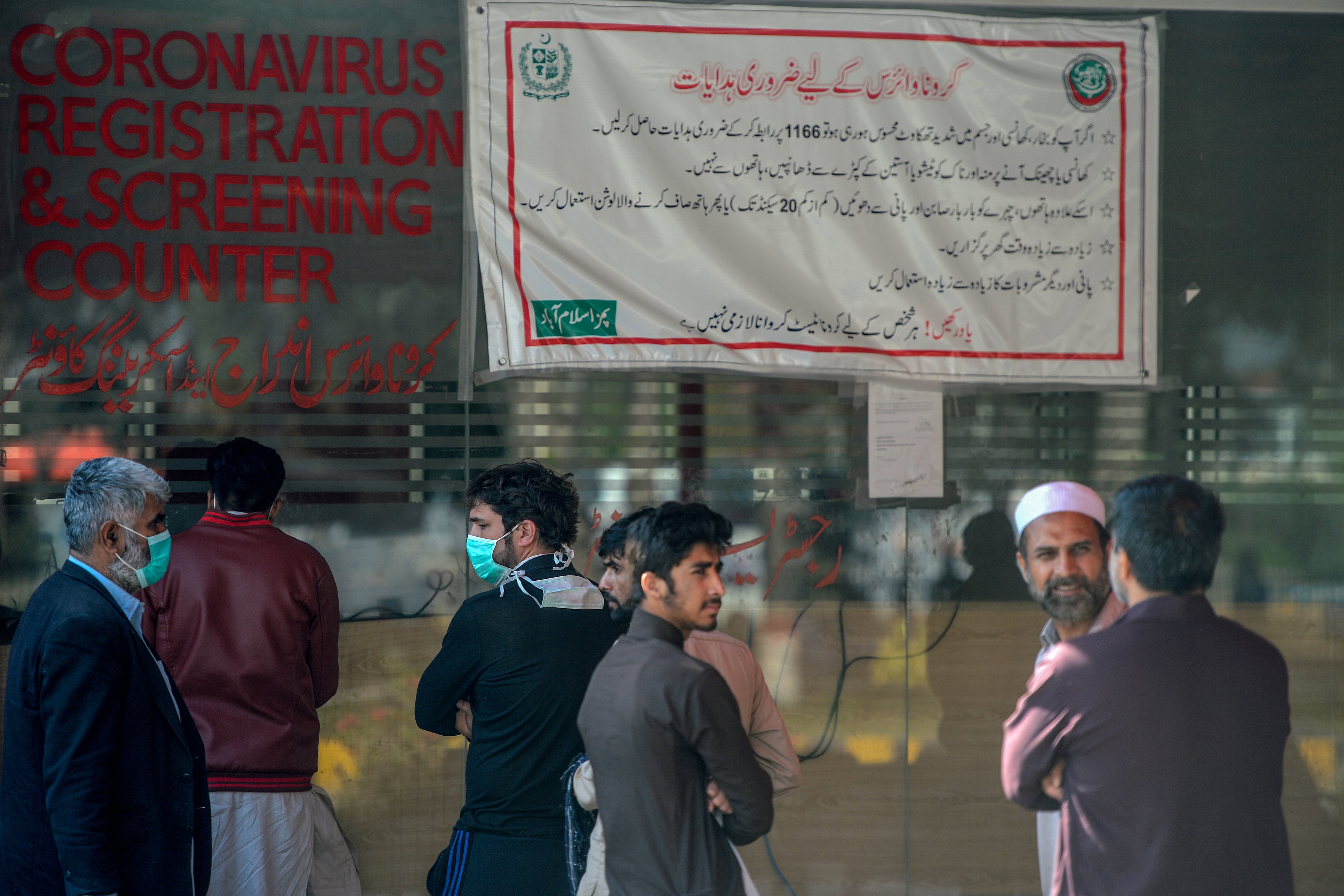 Residents wearing facemasks as a preventive measure against the COVID-19 coronavirus, wait for their turn at a coronavirus registration and screening counter at the Pakistan Institute of Medical Sciences Hospital in Islamabad on March 19, 2020. (AFP)