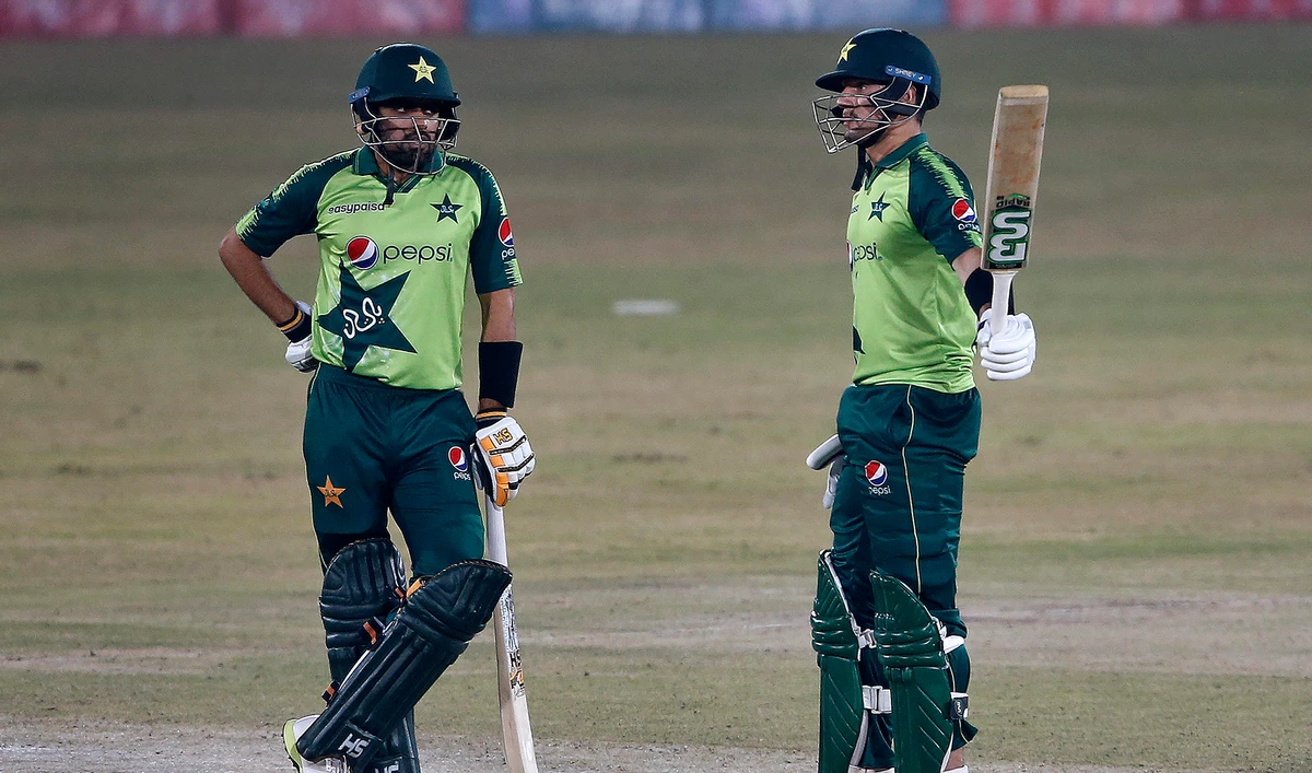 Pakistani batsman Haider Ali, right, raises bat to celebrate his fifty while teammate Babar Azam watches during the 2nd Twenty20 cricket match against Zimbabwe at the Pindi Cricket Stadium, in Rawalpindi on Nov. 8, 2020. (AP)