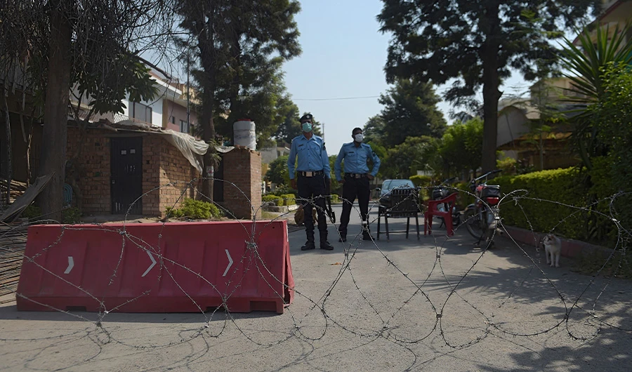 Pakistani policemen wearing facemasks stand guard in front of a cordoned off area after some residents tested positive for Covid-19 coronavirus, in Islamabad on October 11, 2020. (AFP)