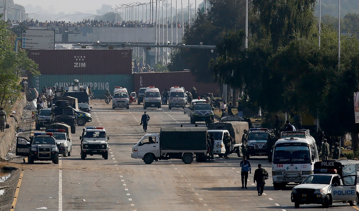 Security vehicles park near shipping containers placed by authorities on a highway to stop supporters of the 'Tehreek-e-Labaik Pakistan, a religious political party, entering into the capital during an anti-France rally in Islamabad on Nov. 16, 2020. (AP)