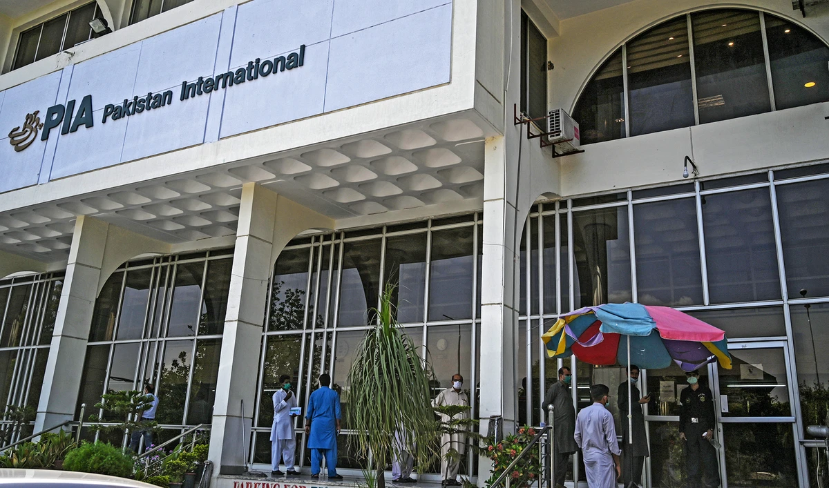 People stand in queue as they wait their turn to buy flight tickets outside Pakistan International Airlines (PIA) office in Islamabad on July 1, 2020. (AFP/File)