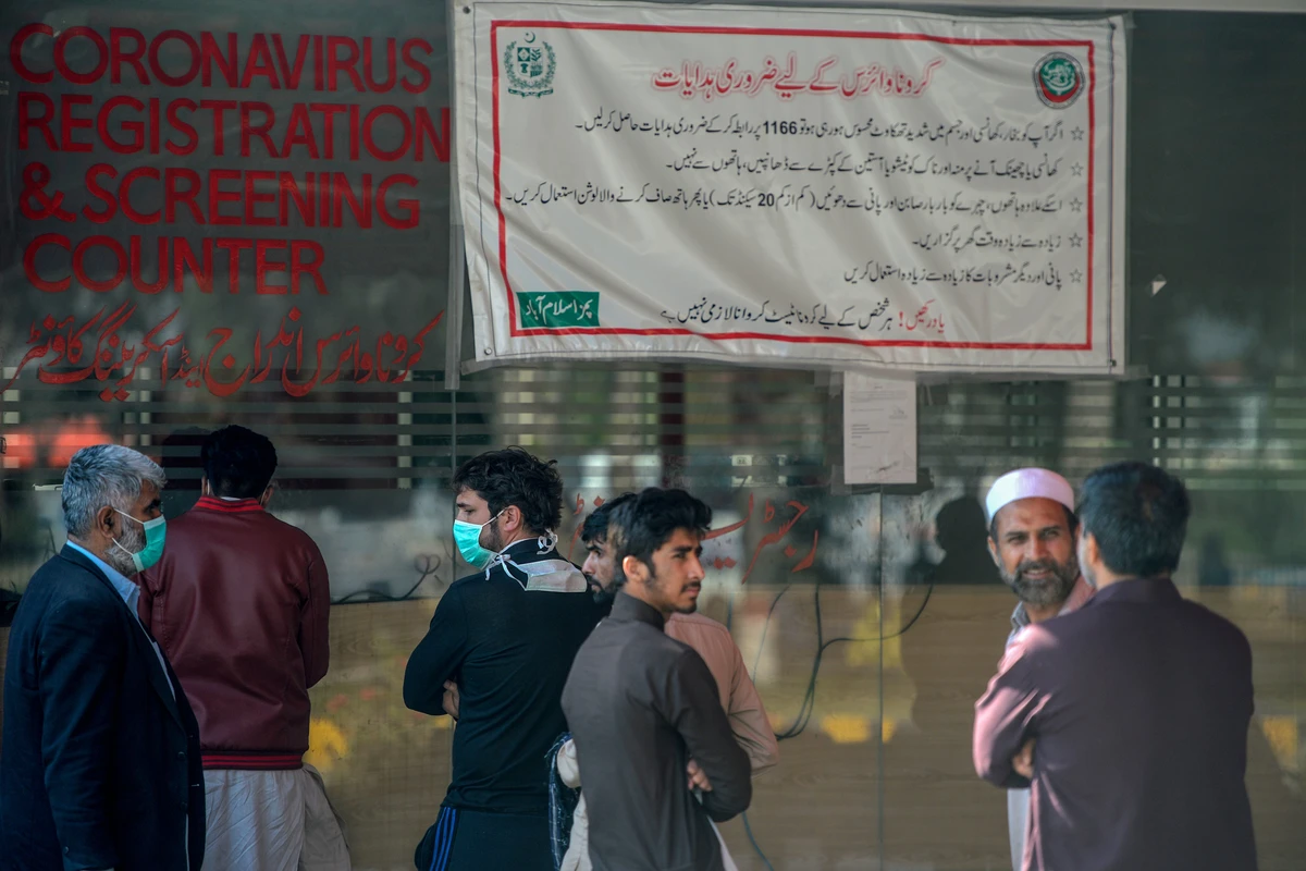 Residents wearing facemasks as a preventive measure against the COVID-19 coronavirus, wait for their turn at a coronavirus registration and screening counter at the Pakistan Institute of Medical Sciences Hospital in Islamabad on March 19, 2020. (AFP)