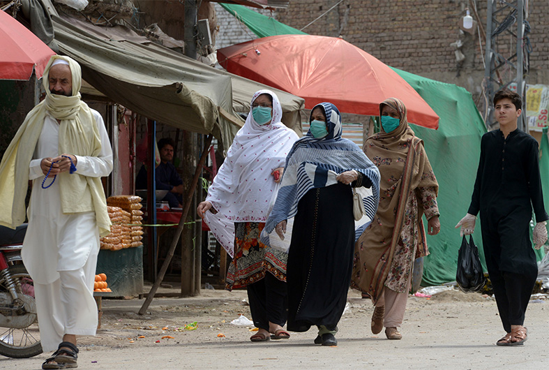 Women wearing facemasks walk on a street during a government-imposed nationwide lockdown as a preventive measure against the COVID-19 coronavirus, in Peshawar on April 6, 2020. (AFP)