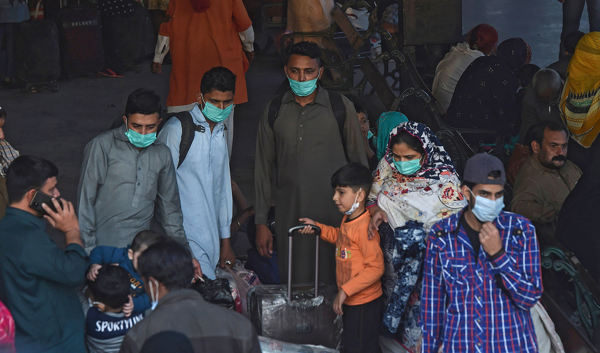 Passengers wearing facemasks as a preventive measure against the Covid-19 coronavirus arrive at the Karachi cantonment railway station in the port city of Karachi on Dec. 1, 2020. (AFP)
