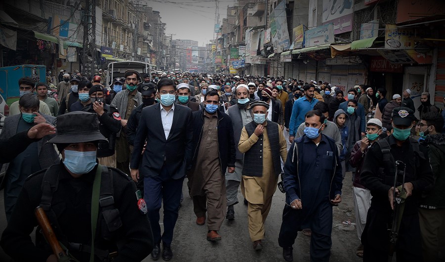 Additional Deputy Commissioner of Peshawar Dr Ahtsham ul Haq (2L) checks the Covid-19 coronavirus standard operating procedure (SOP) at a shop during his visit in a market in Peshawar on November 24, 2020. (AFP)