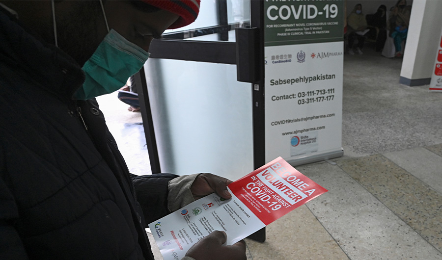 In this picture taken on November 25, 2020 a volunteer reads an information leaflet while waiting to be administered the new Chinese-made vaccine for the Covid-19 coronavirus, the first ever Phase 3 clinical trial for any vaccine in Pakistan, at a hospital in Islamabad. (AFP)