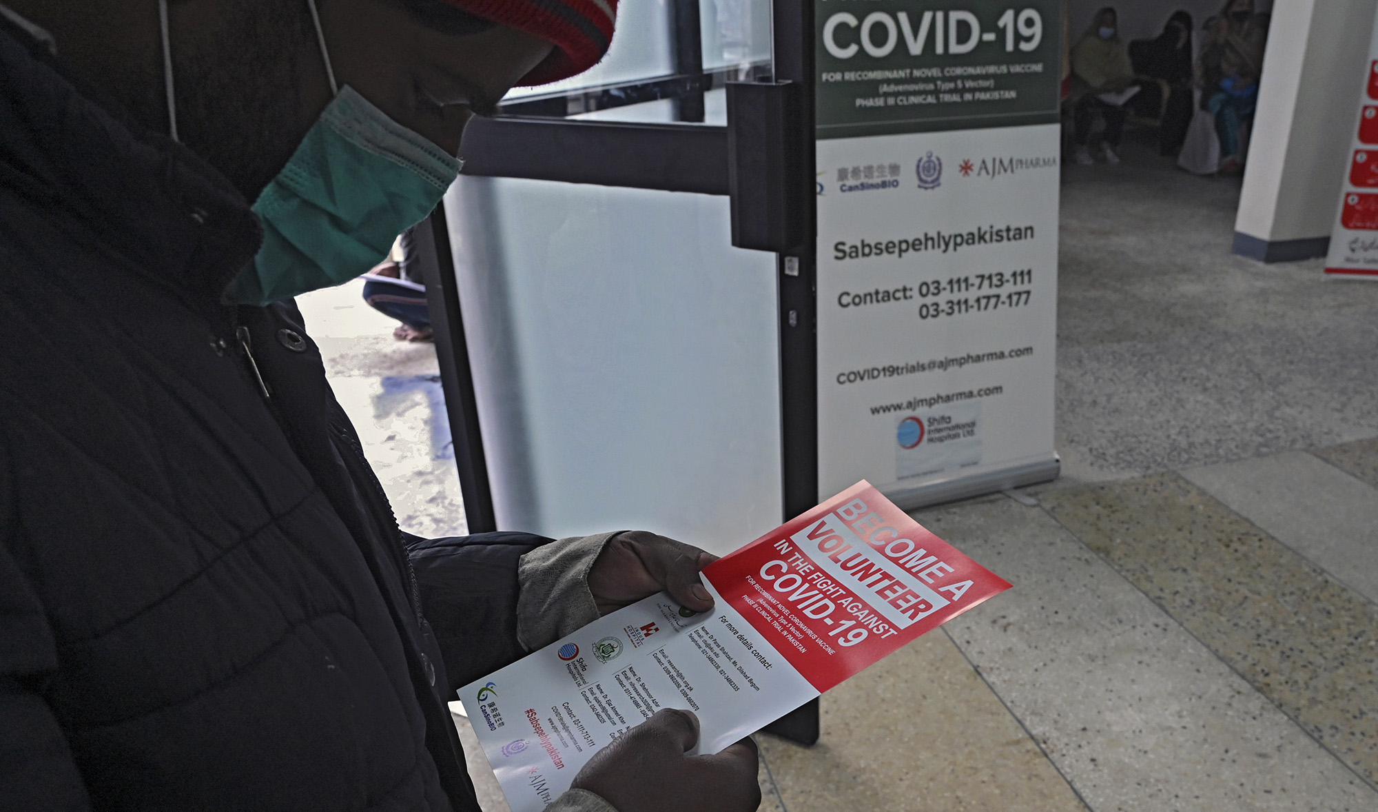 A volunteer reads an information leaflet while waiting to be administered the Chinese-made vaccine for the Covid-19 coronavirus, at a hospital in Islamabad on Nov. 25, 2020. (AFP/File)