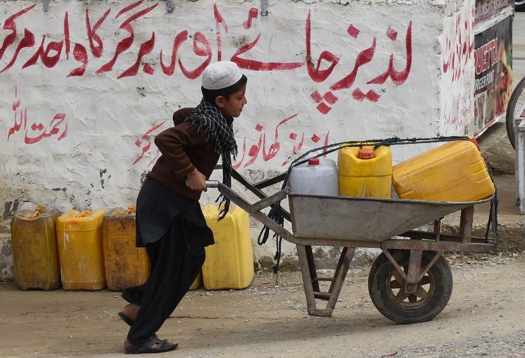 This photo taken on March 17, 2015 shows a Pakistani boy pushing a wheelbarrow loaded with jerry cans full of drinking water from a state-run water tap on the outskirts of Quetta, Balochistan. (AFP/File)