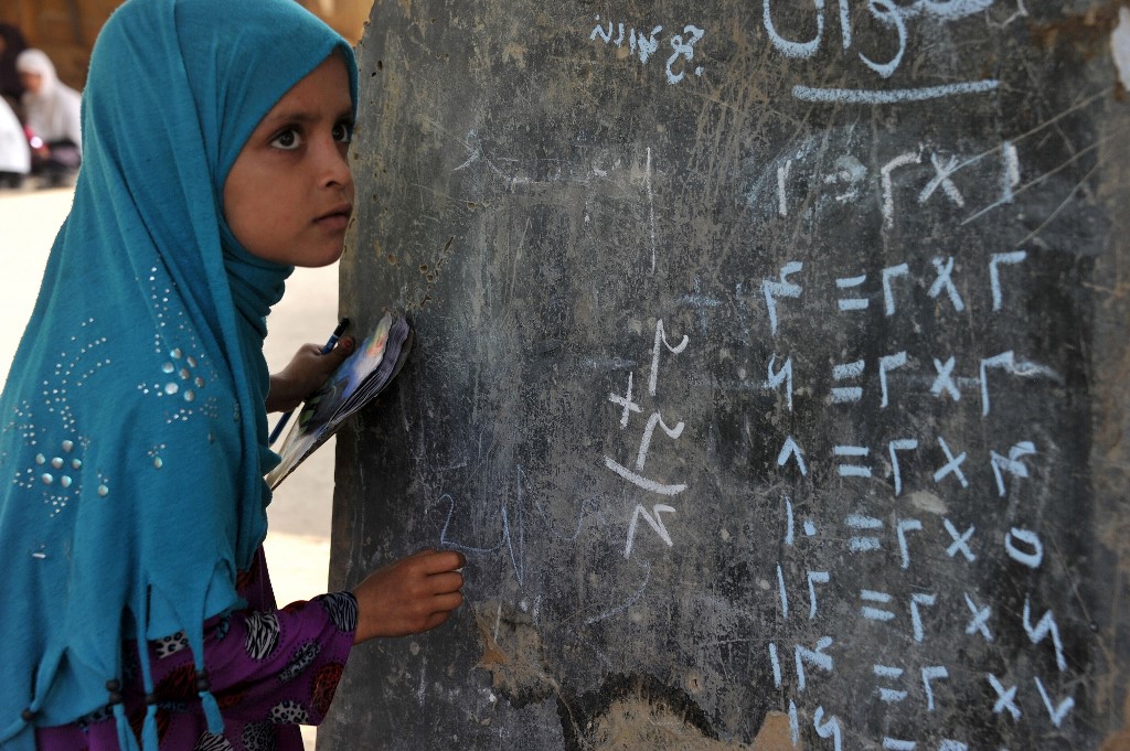 An Afghan child looks up at a blackboard in an open classroom on the outskirts of Jalalabad on September 11, 2013. (AFP/File)