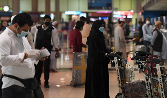 Pakistani nationals check in at the Dubai International Airport before leaving the Gulf Emirate on a flight back to their country, on May 7, 2020, amid the novel coronavirus pandemic crisis. (AFP)