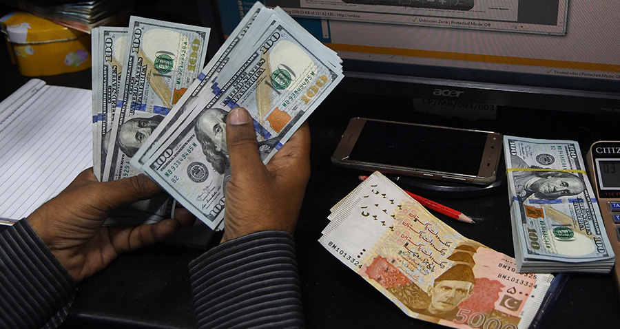 In this picture taken on April 15, 2019, a Pakistani dealer counts US dollars at a currency exchange shop in Karachi. (AFP)