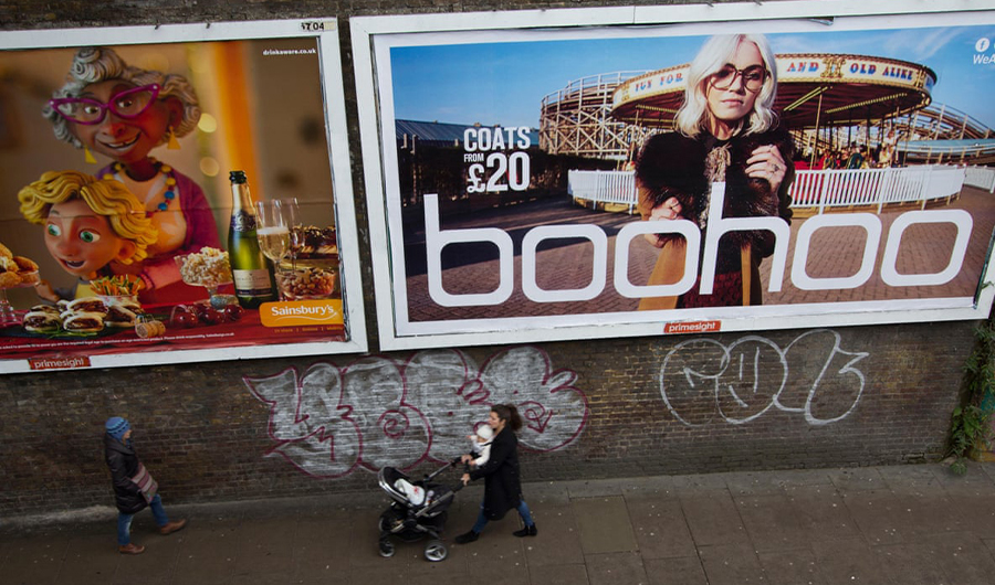In this undated photo, a woman walk past an advertisement of UK's fashion brand Boohoo in Britain. (Photo Courtesy: Alamy)