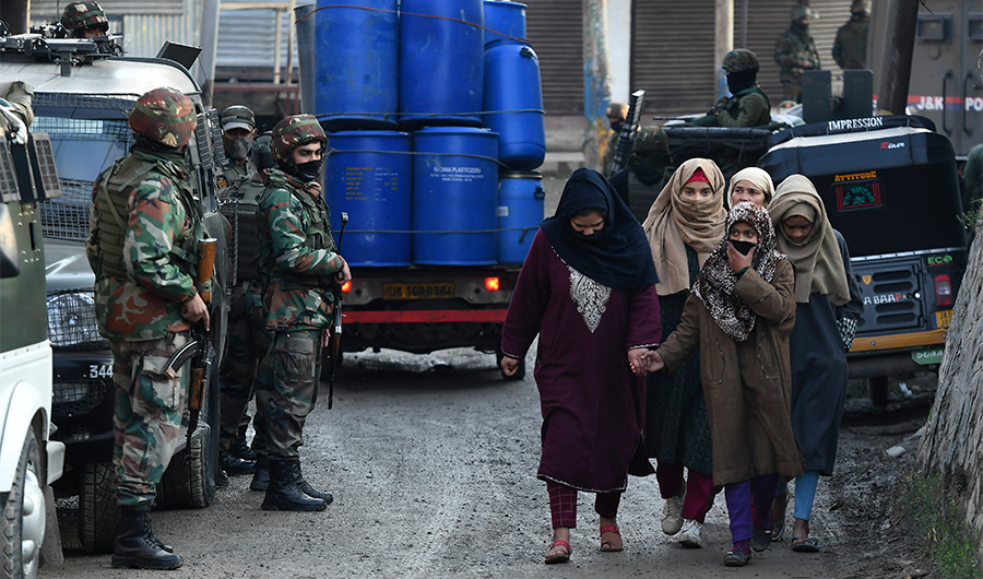 Indian army soldiers stand guard as pedestrians walk past near the site of a shootout where two soldiers were allegedly killed by the suspected militants on the outskirts of Srinagar on November 26, 2020. (AFP/File)