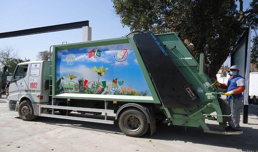 In this undated photo, an Oz Pak worker stands next to a garbage truck. (Photo courtesy: Glassdoor website)