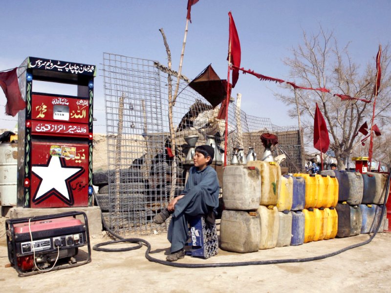 FILE - A boy sits next to plastic canisters filled with petrol brought from Iran, while waiting for customers at a roadside petrol station on the outskirts of Quetta, Pakistan Feb 13, 2019. (REUTERS/ File photo)