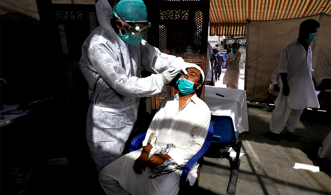 A paramedic wearing protective gear takes a nose-swab sample to be tested for the coronavirus disease (COVID-19), in Karachi, Pakistan June 27, 2020. (REUTERS)