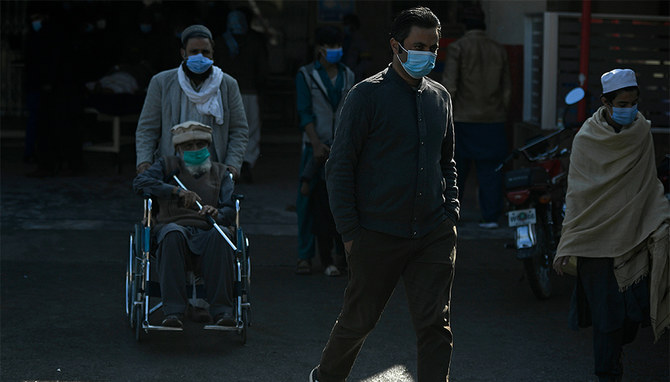 People wearing facemasks as a preventive measure against the Covid-19 coronavirus leave from a hospital in Islamabad on Nov. 26, 2020. (AFP)
