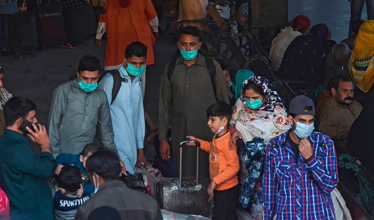 Passengers wearing facemasks as a preventive measure against the Covid-19 coronavirus arrive at the Karachi cantonment railway station in the port city of Karachi on Dec. 1, 2020. (AFP)
