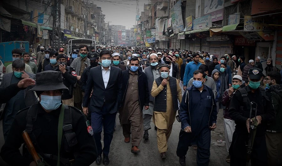 Additional Deputy Commissioner of Peshawar Dr Ahtsham ul Haq (2L) checks the Covid-19 coronavirus standard operating procedure (SOP) at a shop during his visit in a market in Peshawar on November 24, 2020. (AFP)