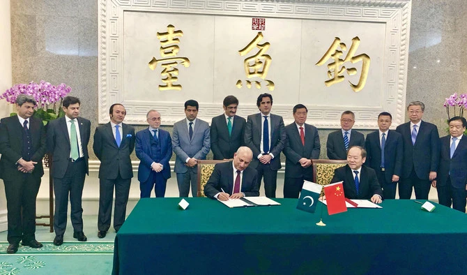 FILE - Haroon Sharif, Minister of State and Chairman of Pakistan Board of Investment, signs an agreement with China for the second phase of the China-Pakistan Economic Corridor (CPEC) project. The deal focuses on investments in industrial ventures of the project. (Photo courtesy: Haroon Sharif/Twitter)