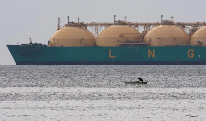 A fisherman stands in his boat as a liquid natural gas tanker (LNG) passes the coast near Havana on June 28, 2009. (REUTERS/File)