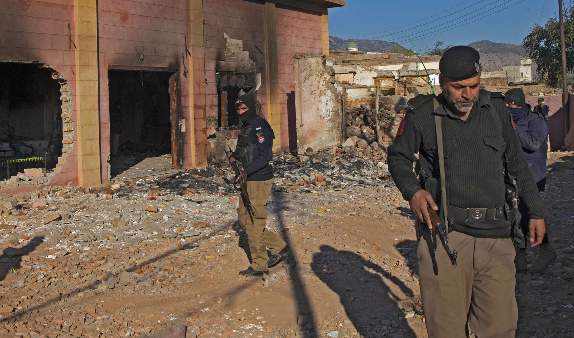 Police officers stand guard in a Hindu temple which was set on fire and demolished by a mob in Karak on Dec. 31, 2020. (AP)