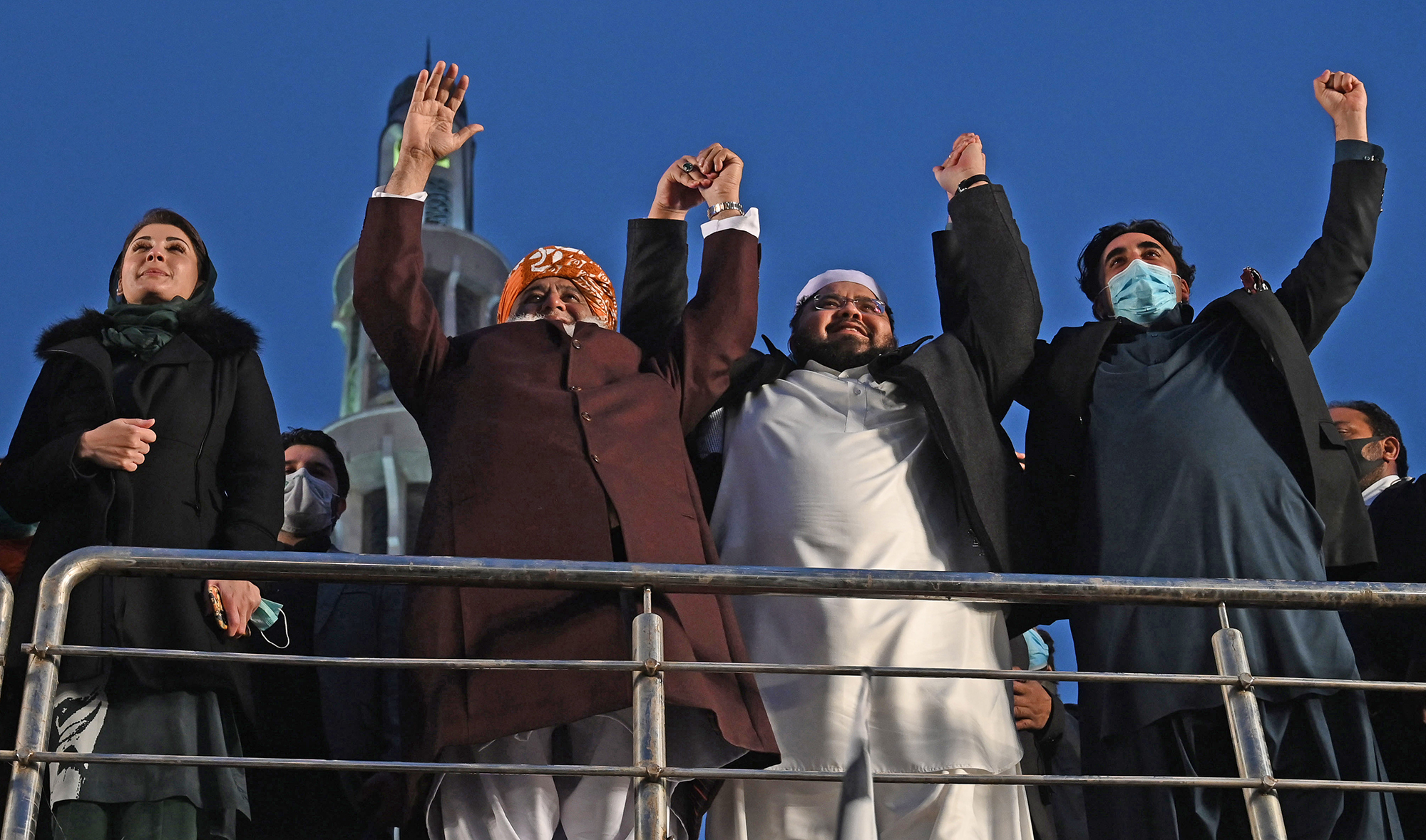 Opposition leaders (R to L) Bilawal Bhutto Zardari, Owais Noorani, Maulana Fazlur Rehman and Maryam Nawaz of Pakistan Democratic Movement (PDM) joint hands as they arrive to attend an anti-government rally in Lahore on Dec. 13, 2020. (AFP/File)