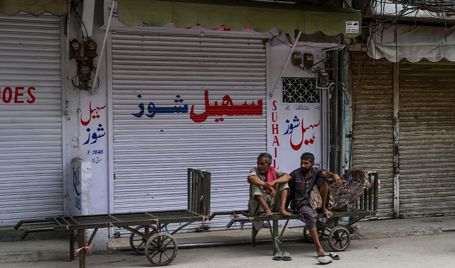 Labourers sit on a hand-cart at a closed market in Lahore on July 30, 2020, after the Punjab province government announced a lockdown closing markets, shopping malls and plazas to contain the spread of the COVID-19 coronavirus on the occasion of the Muslim festival Eid al-Adha or the 'Festival of Sacrifice'. (AFP)