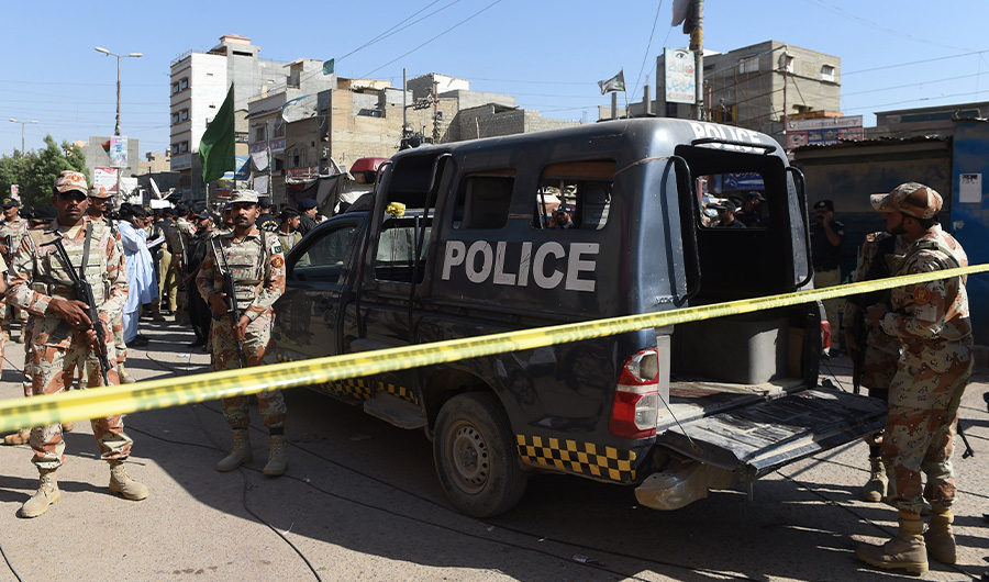 Pakistani security personnel gather around a police van after an attack by gunmen on security members guarding a polio vaccination team in Karachi on April 20, 2019. (AFP/File)