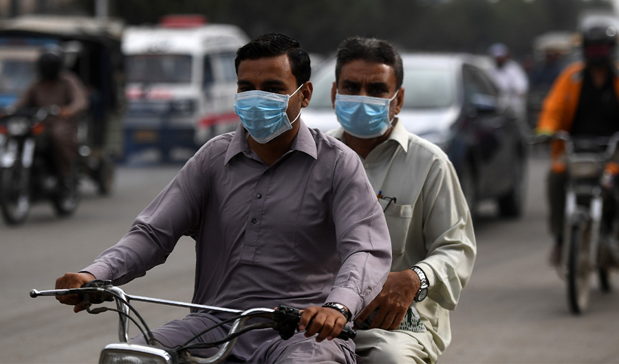 Commuters wear face masks on a street in Karachi on February 28, 2020. (AFP/File)