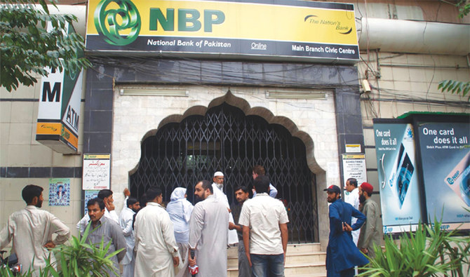 In this undated photo, people standing outside the building of National Bank of Pakistan. (APP)