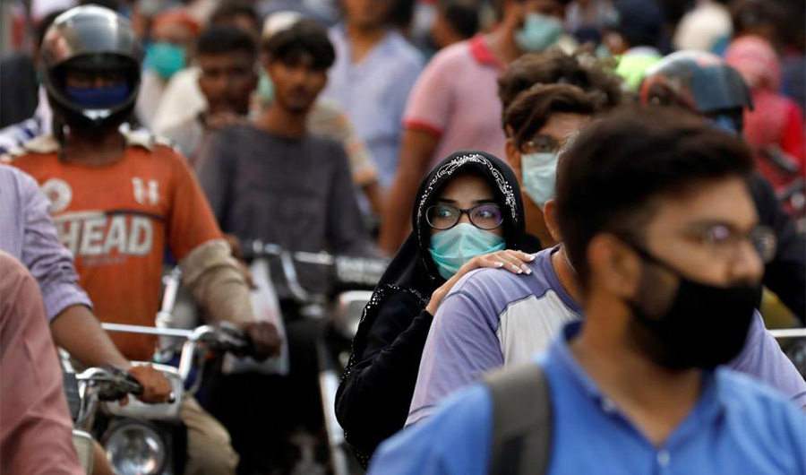 A woman rides on a motor bike as she wears a protective face mask amid the rush of people outside a market as the outbreak of the coronavirus disease (COVID-19) continues, in Karachi, Pakistan June 8, 2020. (REUTERS/File)