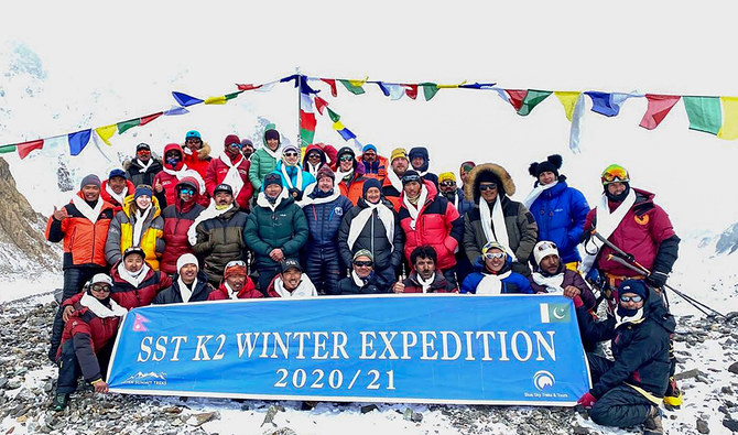 This handout photo taken on January 16, 2021 and released by Seven Summit Treks, shows mountaineers and Sherpas posing for pictures after reaching the summit of Mt K2, which is the second highest mountain in the world, at the Base Camp of the winter expedition in the Gilgit-Baltistan region of northern Pakistan. (Seven Summit Treks via AFP)