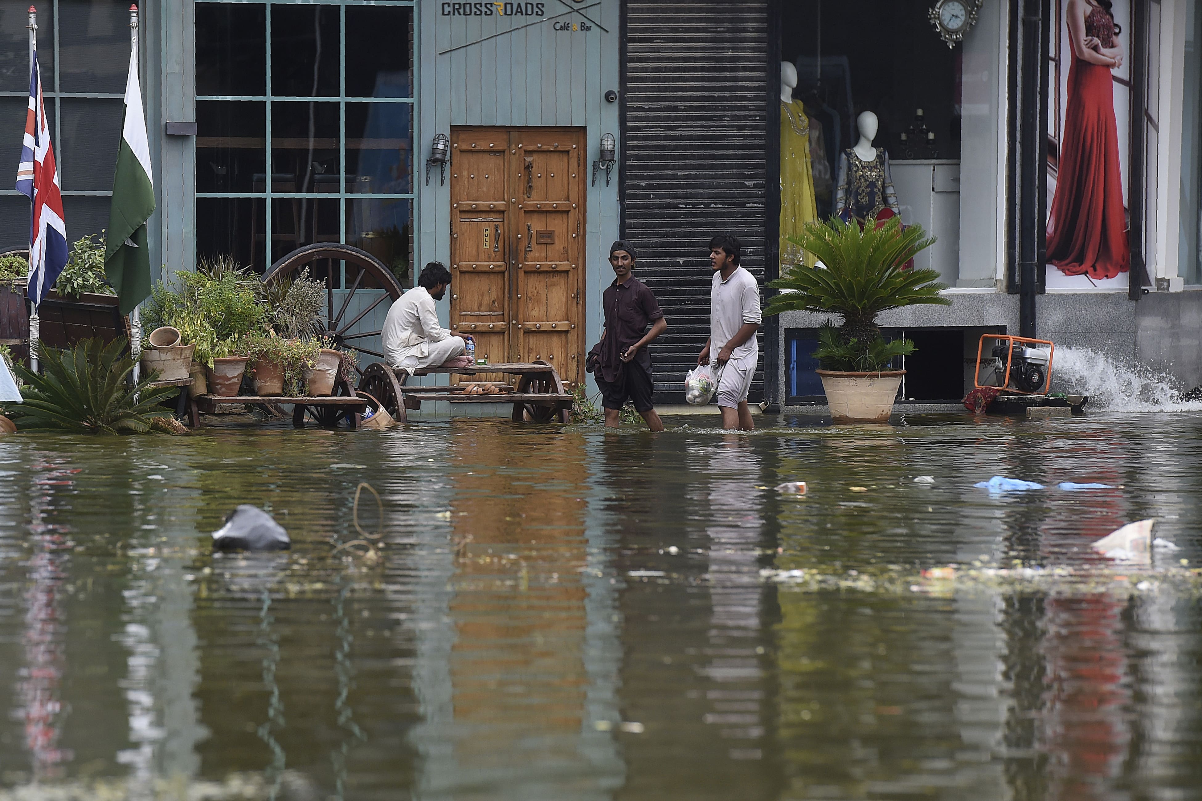 People wade through a flooded residential area following heavy monsoon rains triggered floods in Pakistan's port city of Karachi on August 31, 2020. (AFP)