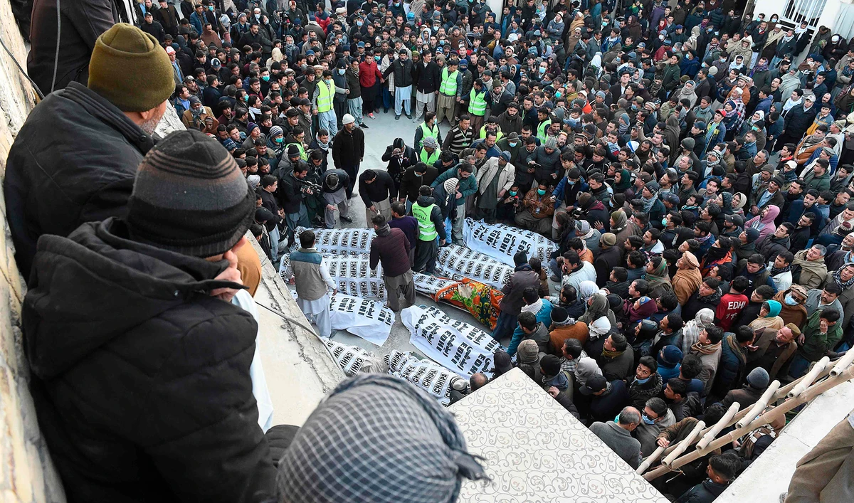 Members of Shiite Hazara community gather around coffins of victims after the killing of 11 workers of their community, in Quetta on Jan. 3, 2021. (AFP)